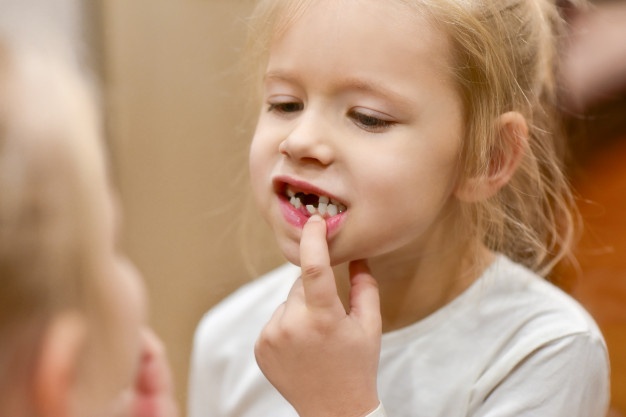 child-girl-looks-mirror-changing-baby-teeth-her-mouth_94132-1115